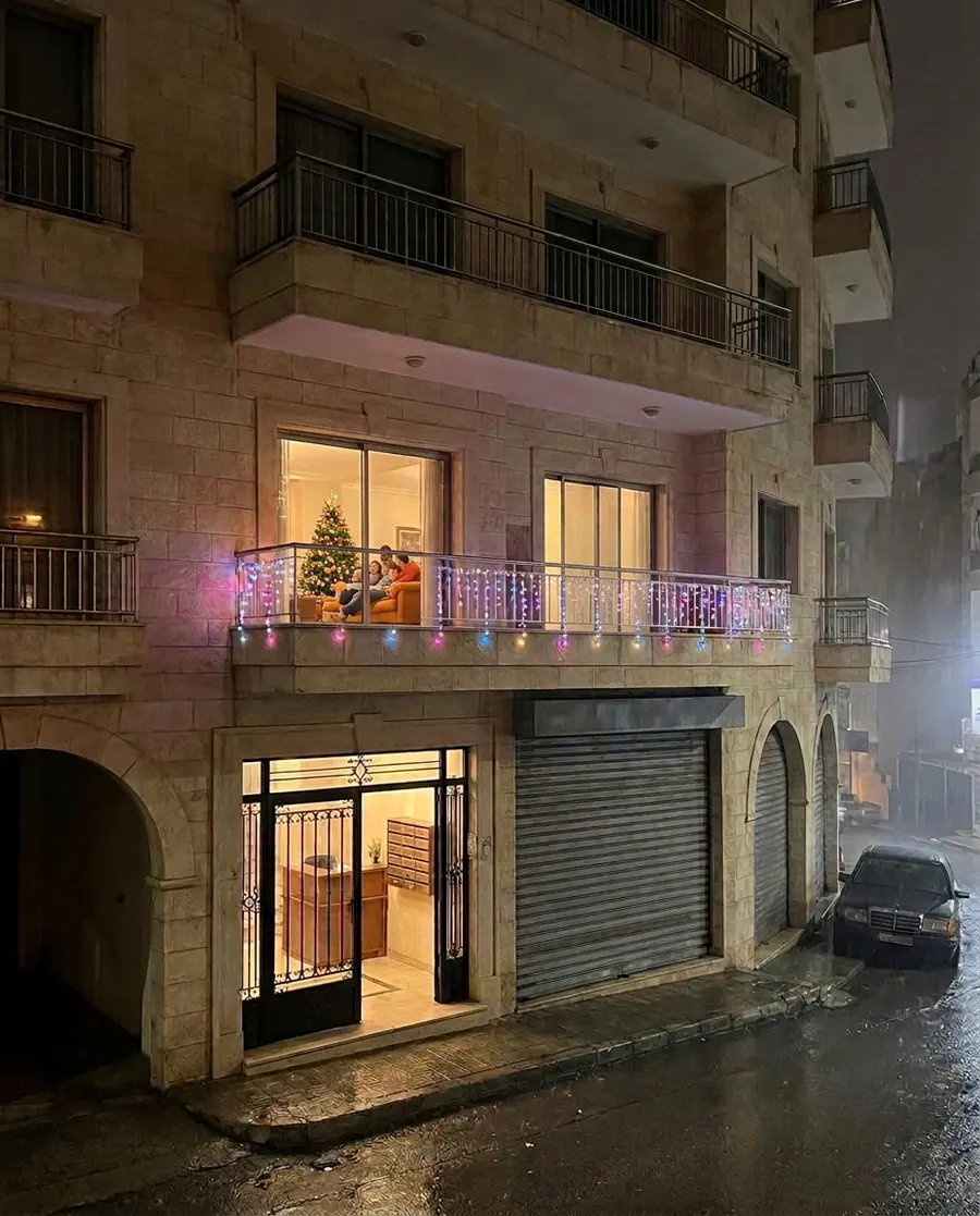A Lebanese building on a rainy night with colourful Govee icicle lights along a balcony